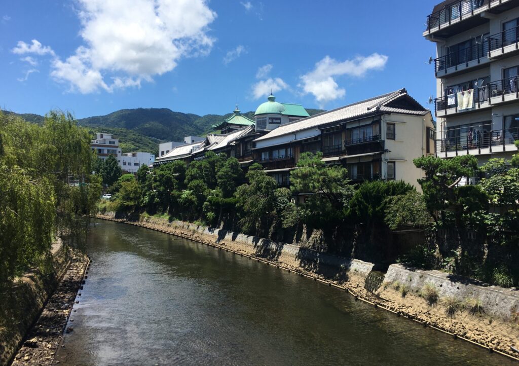 伊東駅から界 アンジンへ徒歩で向かう途中の川沿い風景。自然と温泉街の情緒が感じられる道のり。
